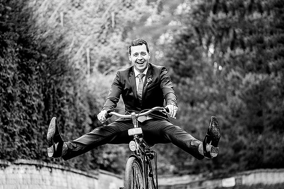 Groom having fun on a bike at Cowley manor